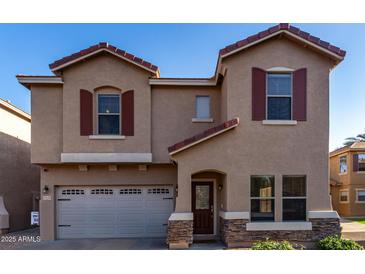 Inviting two-story home featuring a well-manicured front yard, a red tile roof, and a two-car garage at 2116 S Shelby --, Mesa, AZ 85209
