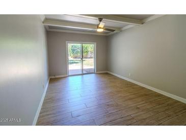 Bright bedroom featuring wood-look tile floors and a sliding glass door to the backyard at 357 E Thomas Rd # A112, Phoenix, AZ 85012