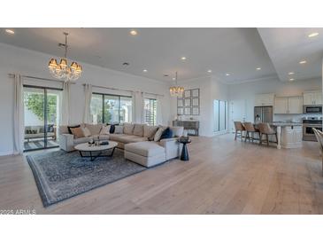 Bright and open living room with hardwood floors, a large sectional sofa, and access to the backyard at 10532 N 79Th St, Scottsdale, AZ 85258