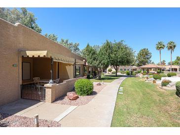 Condo exterior with covered patio and well-maintained landscaping at 14300 W Bell Rd # 100, Surprise, AZ 85374