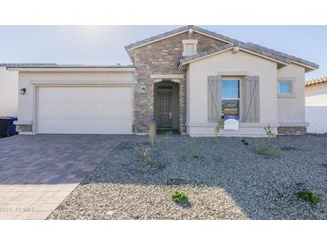 Charming single-story home featuring stone accents, a two-car garage, and desert landscaping at 16355 W Desert Mirage Dr, Surprise, AZ 85388