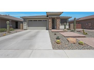 Charming single-story home featuring desert landscaping, a two-car garage, and a brick-accented entryway at 18746 W Rancho Dr, Litchfield Park, AZ 85340