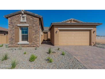 Charming home exterior featuring stone accents, a two-car garage, and low-maintenance desert landscaping at 18938 W Ocotillo Rd, Waddell, AZ 85355