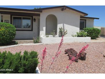 Charming single-story home with an arched entryway, desert landscaping, and well-maintained exterior at 2324 W Via Rialto Cir, Mesa, AZ 85202