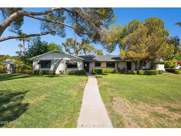 Charming single-story home featuring a well-manicured lawn, mature trees, and a welcoming walkway at 6800 E Exeter Blvd, Scottsdale, AZ 85251