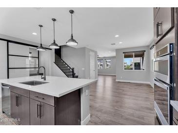 Modern kitchen with stainless steel appliances, a large island, and pendant lighting at 687 W Flintlock Way, Chandler, AZ 85286