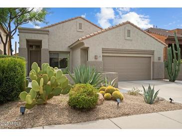 Beautiful desert landscaping complements the facade of this single-story home with a two-car garage at 7673 E Sands Dr, Scottsdale, AZ 85255