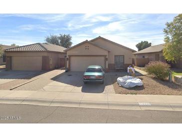 Charming single-story home featuring a low-maintenance front yard, attached garage, and desert landscaping at 8921 W Laurel Ln, Peoria, AZ 85345