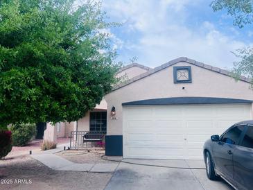 Charming single-story home with a two-car garage, desert landscaping and a mature shade tree at 1616 W Burgess Ln, Phoenix, AZ 85041