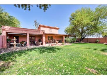 A spacious backyard with lush grass, trees, and a covered patio perfect for outdoor relaxation and entertaining at 17705 E Canyon Way, Gilbert, AZ 85298
