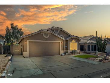 Inviting front exterior view of the home with a two car garage and lovely desert landscaping at sunset at 18845 N 23Rd Pl, Phoenix, AZ 85024