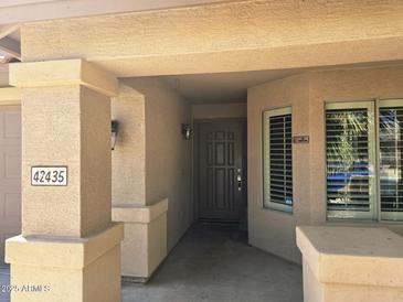 Inviting entryway with neutral tones, decorative pillars, and a secure front door at 42435 W Desert Fairways Dr, Maricopa, AZ 85138