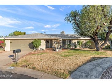 Charming single-story home featuring a welcoming front yard with beautiful mature landscaping at 9221 N Camino Vista Ln, Phoenix, AZ 85028