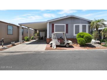 Charming house with a golf cart, a covered driveway, and landscaping at 17200 W Bell Rd # 1748, Surprise, AZ 85374