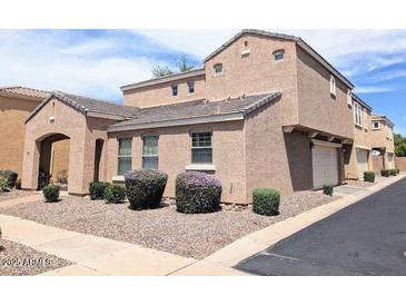 Two-story tan home featuring arched entry and well-manicured landscaping at 3020 E Megan St, Gilbert, AZ 85295
