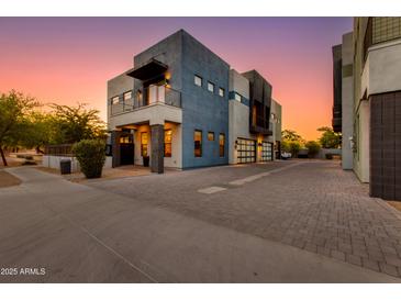 Striking modern home showcasing a private balcony and spacious driveway under a vivid sunset sky at 340 E Osborn Rd # 1, Phoenix, AZ 85012