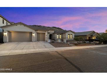 Charming single-story home featuring a three-car garage, desert landscaping, and a welcoming facade at 3551 W Hidden Mountain Ln, Anthem, AZ 85086