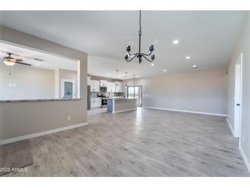 Open-concept living area with wood-look tile flooring, recessed lighting, and kitchen view at 3887 S 331St Ave, Tonopah, AZ 85354