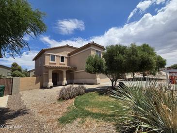 Charming two-story home featuring a covered porch and well-maintained landscaping at 44328 W Knauss Dr, Maricopa, AZ 85138