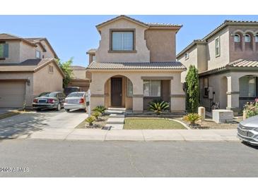 Charming two-story home features a stucco facade, a tiled roof, and a well-manicured front yard at 11983 W Fillmore St, Avondale, AZ 85323
