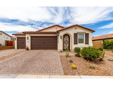 Charming single-story home featuring a three-car garage, desert landscaping, and a decorative front door at 19858 W San Juan Ave, Litchfield Park, AZ 85340