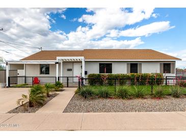 Charming single-story home featuring a landscaped front yard with decorative rock and an inviting walkway to the front door at 2242 E Palm Ln, Phoenix, AZ 85006