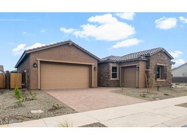 Beautiful home showcasing a well-maintained front yard, a two-car garage, and a stone accent exterior at 22523 E Orchard Ln, Queen Creek, AZ 85142