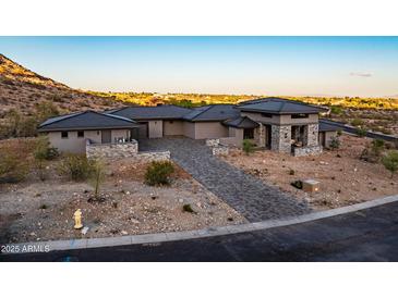 Inviting single-Gathering home with desert landscaping, brick driveway, and a stone-accented entrance in a desirable location at 3135 N Mountainside Loop, Buckeye, AZ 85396