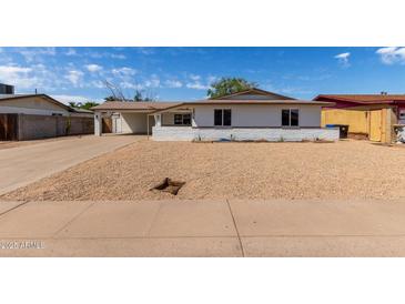 Charming single-story home with a low brick wall and a spacious driveway, perfect for comfortable living at 3826 W Davidson Ln, Phoenix, AZ 85051
