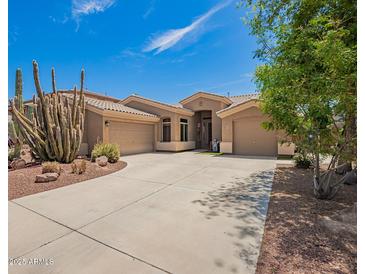 Charming single-story home featuring desert landscaping, a spacious driveway, and a welcoming facade with a large 3-car garage at 4667 E County Down Dr, Chandler, AZ 85249