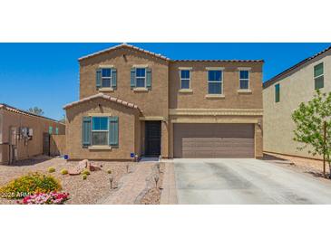 Charming two-story home featuring a desert landscape, tile roof, and attached two-car garage at 7112 N 126Th Ln, Glendale, AZ 85307