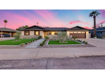 Charming single-story home with an inviting front yard, lush landscaping, and a two-car garage at 8117 E Lewis Ave, Scottsdale, AZ 85257