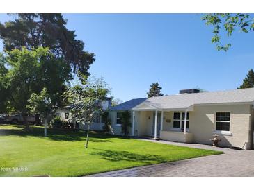 Charming single-story home with a well-manicured lawn and lovely curb appeal at 930 W Mackenzie Dr, Phoenix, AZ 85013