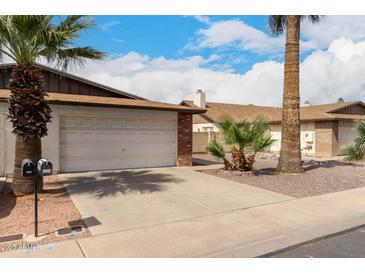Exterior view of a one story home with a 2-car garage and desert landscaping at 2524 W Kiva Ave, Mesa, AZ 85202