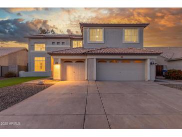 Stunning two-story home featuring a three-car garage and tile roof at sunset at 2754 E Michelle Way, Gilbert, AZ 85234