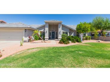 Beautiful single-story home with a lush green lawn and mature desert landscaping at 3544 E Fox St, Mesa, AZ 85213