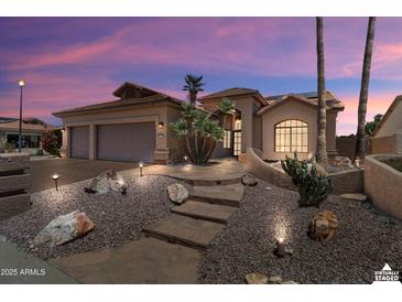Stunning home featuring desert landscaping, stone pathway, a two-car garage, and vibrant sunset skies at 3797 N 156Th N Dr, Goodyear, AZ 85395