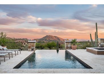Inviting infinity pool and spa offer stunning mountain views at sunset, perfect for relaxing or entertaining at 42155 N 97Th Way, Scottsdale, AZ 85262