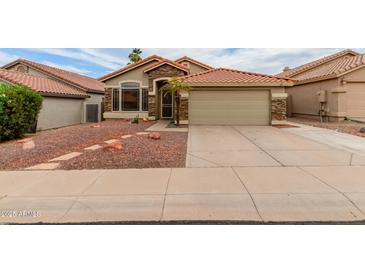 Charming single-Gathering home with a terracotta roof, desert landscaping, and stone accents at 1011 E Amberwood Dr, Phoenix, AZ 85048