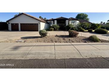 Charming single-Gathering home featuring a tile roof, desert landscaping, and a spacious driveway at 10205 E Corrine Dr, Scottsdale, AZ 85260