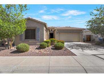 Charming single story home with desert landscaping, tan exterior, and a two car garage at 18023 W Statler St, Surprise, AZ 85388