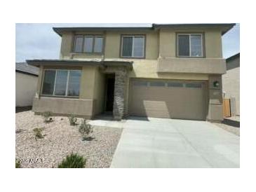 Two-story home with a two car garage, landscaped front yard, and neutral color palette at 37568 W Patterson St, Maricopa, AZ 85138