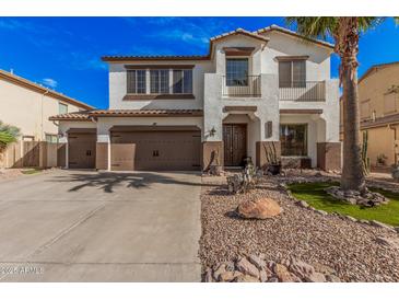 Charming two-story home with a three car garage, desert landscaping, and inviting curb appeal at 45247 W Jack Rabbit Trl, Maricopa, AZ 85139
