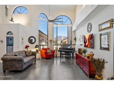 Bright living room featuring large windows, tile floors, piano, and elegant furnishings at 8879 E Greenview Dr, Gold Canyon, AZ 85118