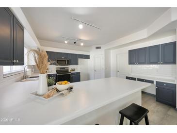Bright kitchen features white countertops and stylish gray cabinets for a modern, inviting space at 11832 E Clinton St, Scottsdale, AZ 85259
