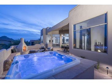 Enjoy the outdoors with the hot tub, fireplace, and seating area on the back patio at 28437 N 112Th Way, Scottsdale, AZ 85262