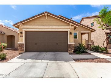 Charming home featuring a two car garage, rock accents and low maintenance landscaping at 14355 W Valentine St, Surprise, AZ 85379