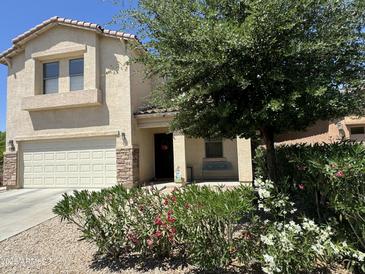 Charming home with a landscaped front yard and a cozy covered porch perfect for relaxation at 20426 N Alma Dr, Maricopa, AZ 85138