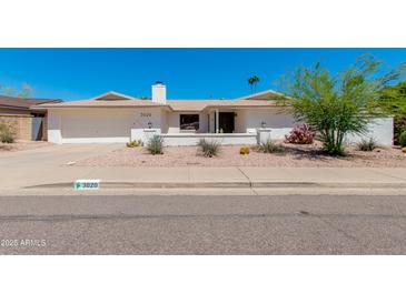 Charming home featuring desert landscaping, an attached garage, and a welcoming front entrance at 3020 E Mission Ln, Phoenix, AZ 85028
