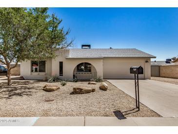 Charming single-story home features a two-car garage, desert landscaping, and a cozy front porch at 4121 W Paradise Dr, Phoenix, AZ 85029
